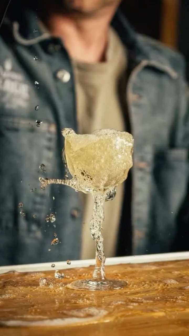 A cocktail glass caught mid-splash