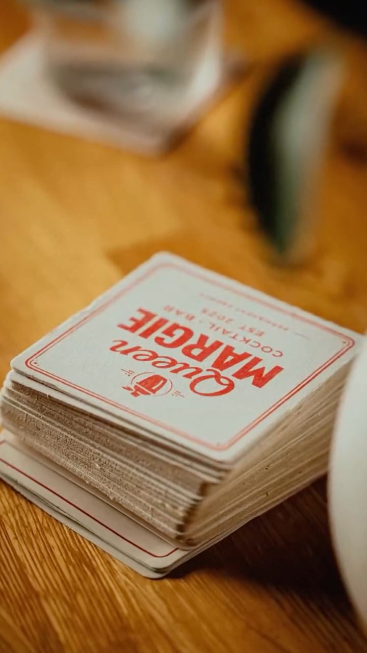 A stack of Queen Margie coasters on the bar